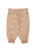 Blumenmuster-Hosen aus weichem, leichtem Stoff mit einem gerafften Bund und elastischen Bündchen. Die Muster zeigen rosa und braune Farbtöne auf einem cremefarbenen Hintergrund.
