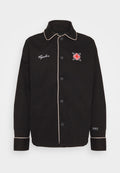 Schwarze Knopfjacke mit einem kontrastierenden, hellen Kragen und Manschetten, versehen mit einem bestickten Logo auf der Brust und fünf Knöpfen an der Vorderseite.