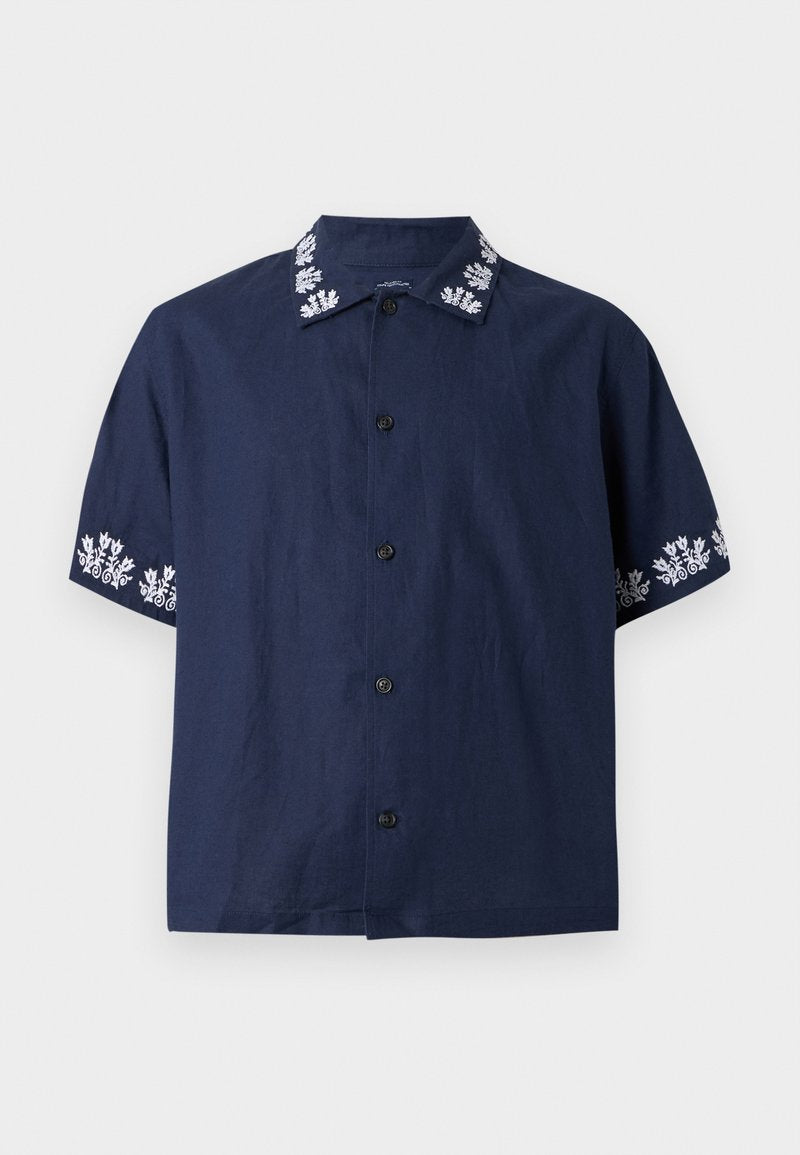 Marineblaue Kurzarm-Hemdjacke mit weißer Blumenstickerei an Kragen und Ärmelkanten, glatter Vorderseite und schwarzen Knöpfen.