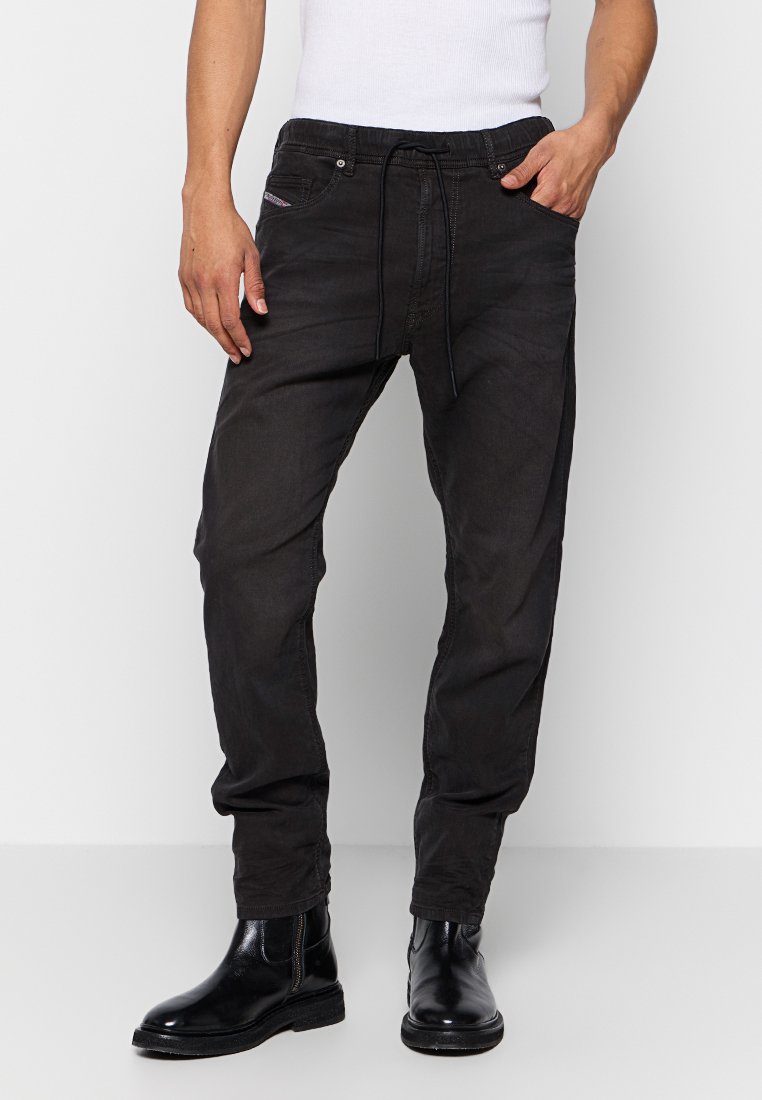 Schwarze, tapered Jogginghosen mit elastischem Bund und Kordelzug. Aus Denim gefertigt, mit Fronttaschen und dezenten Nähdetails.