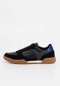 Schwarzer Sneaker aus Wildleder- und Leder-Material. Verfügt über eine braune Gummisohle, perforierte Details und einen mehrfarbigen Akzent an der Seite.