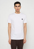Weißes T-Shirt aus Baumwolle mit kurzen Ärmeln, Rundhalsausschnitt und einem kleinen schwarzen Logopatch auf der linken Brust. Glatte Textur und normale Passform.