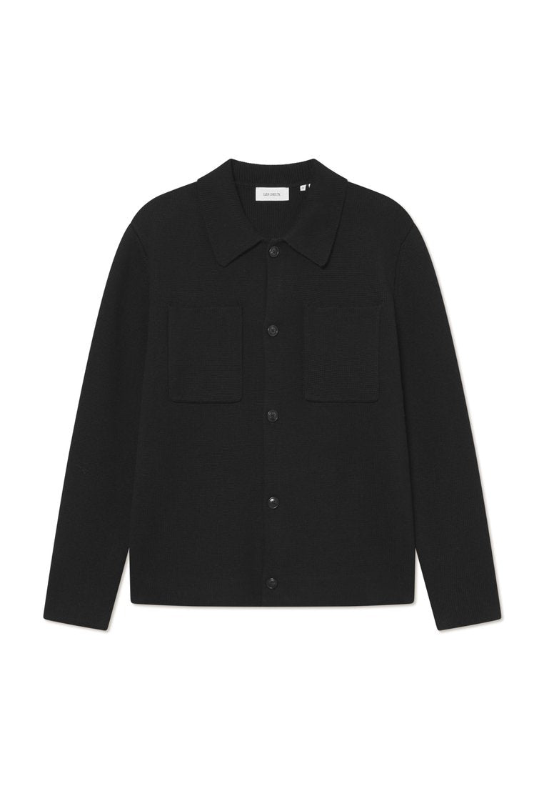 Schwarzer Cardigan aus geripptem Stoff, mit kragenförmigem Ausschnitt, zwei aufgesetzten Fronttaschen und Knopfverschluss in der Mitte.