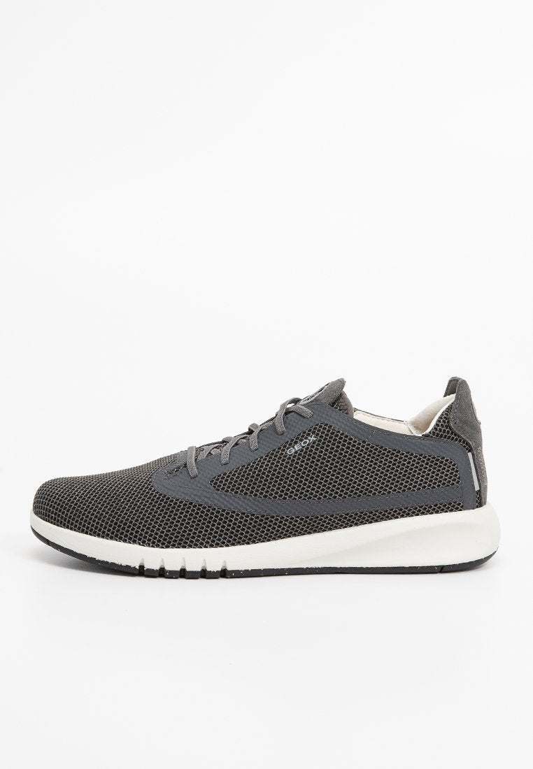 Grau Netzsneaker mit einem atmungsaktiven Obermaterial, abgerundeter Zehenpartie, Schnürung vorne und einer weißen Dämpfungssohle. Mit dezentem Branding an der Seite.