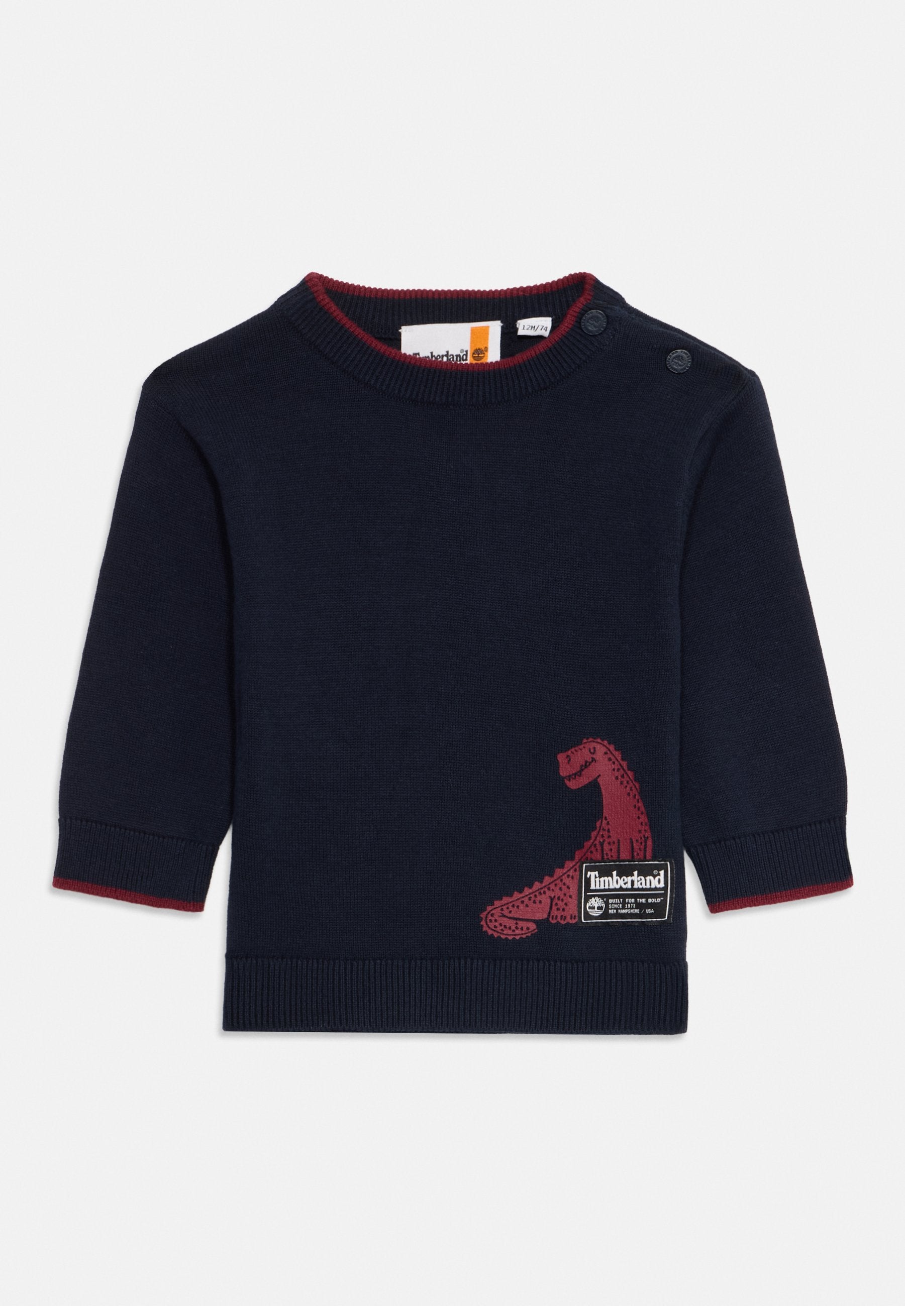Navy blauer Strickpullover mit einem roten Dinosaurier-Graphic auf der Vorderseite, einem gerippten Kragen und Ärmeln sowie Knopfdetails an einer Schulter.
