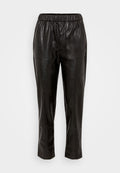 Schwarze Lederhosen mit elastischem Bund, ausgestattet mit zwei seitlichen Taschen und einem schmal zulaufenden Bein. Glatte Textur und minimale Details.