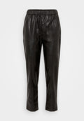 Schwarze Lederhosen mit elastischem Bund, ausgestattet mit zwei seitlichen Taschen und einem schmal zulaufenden Bein. Glatte Textur und minimale Details.