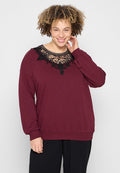 Burgunderfarbener Pullover mit langen Ärmeln, Spitzenverzierungen am Halsauschnitt und entspannter Passform. Weiche Textur mit gerippten Bündchen und Saum.