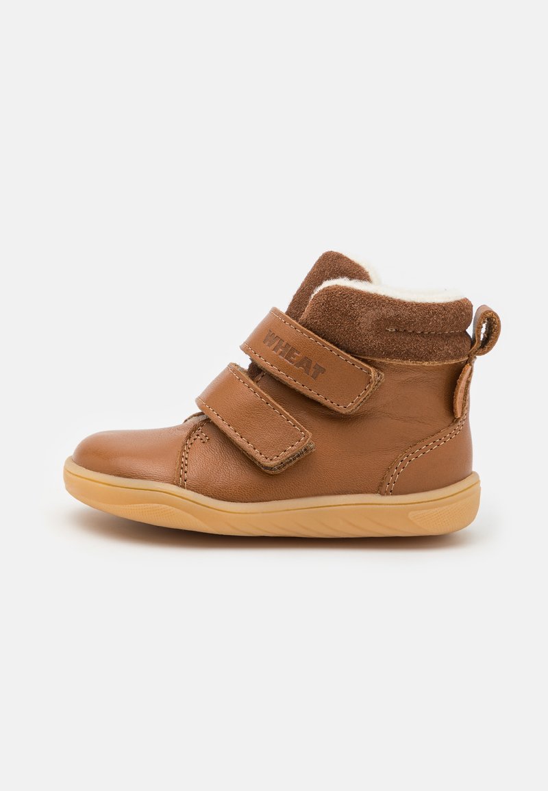 Braune Leder-Mid-Top-Stiefel für Kleinkinder mit zwei Velcro-Riemen, beigem Futter, weicher Textur und Gummisohle. Verfügt über eine kleine Schlaufe am Fersenbereich.