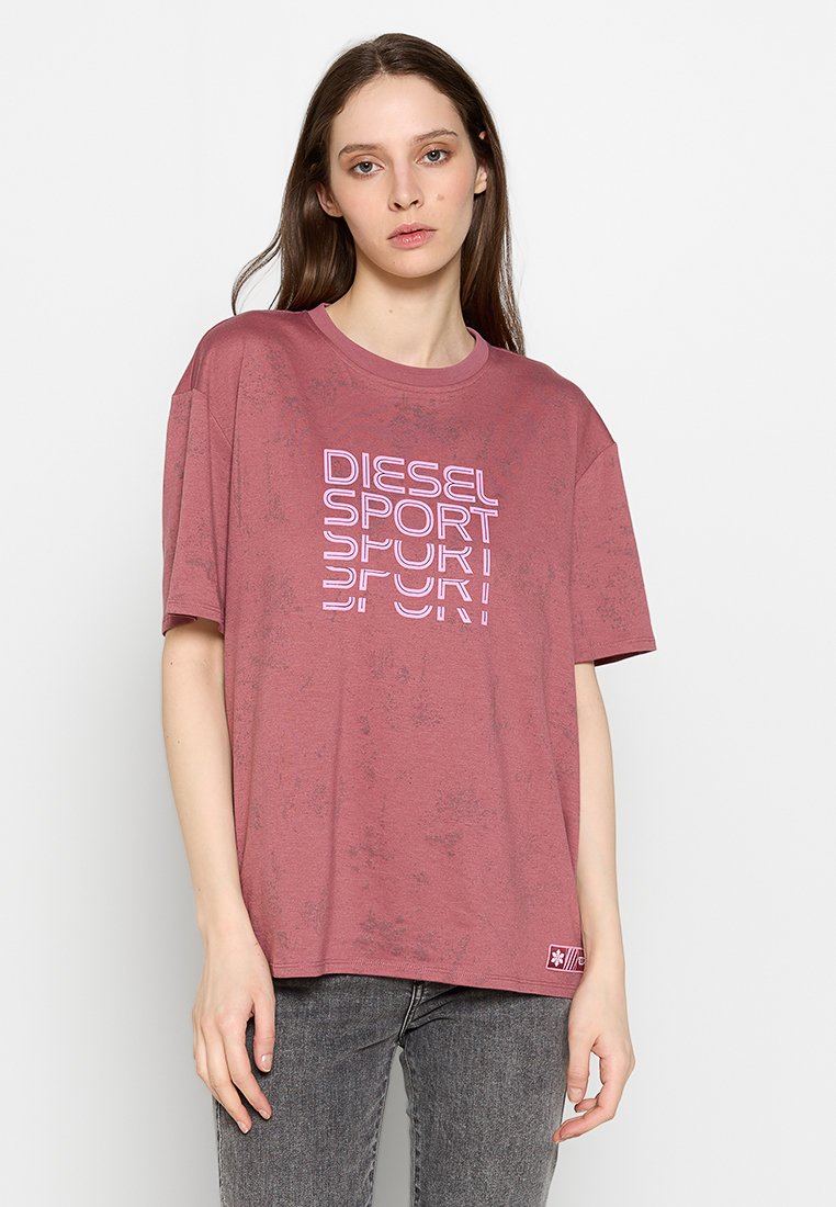 Weinrotes, übergroßes T-Shirt aus weichem Baumwollmaterial mit einem auffälligen weißen "DIESEL SPORT"-Textdesign. Mit kurzen Ärmeln und rundem Ausschnitt.