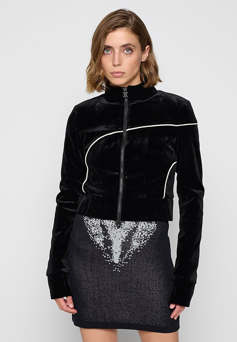 Schwarze Samt-Cropped-Jacke mit hohem Kragen, Frontreißverschluss und kontrastierenden weißen Paspeln. Mit langen Ärmeln und einer weichen Textur.