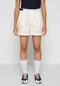Hellbeige Shorts mit glatter Textur, einem Gürtelbund und zwei Seitentaschen. Getragen mit schwarzen Sportschuhen und weißen Socken.