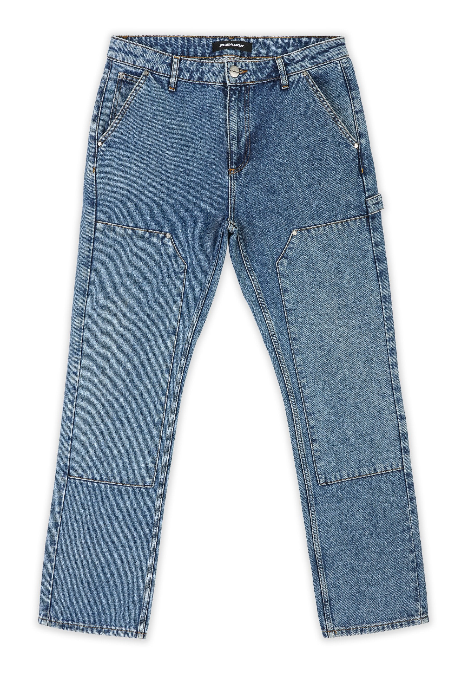Helle blaue Denim-Jeans mit lockerer Passform, ausgestattet mit Flicken-Details an den Beinen, vier Taschen und einem klassischen Knopf- und Reißverschluss.