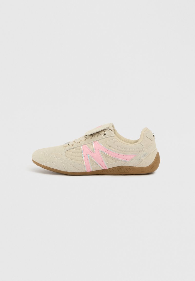 Beige Sport Schuh mit pinken Akzenten, Obermaterial aus Wildleder, texturiertem Muster, flachem Design und Gummisohle für besseren Halt.