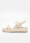 Beige Plateausandale mit zwei breiten Vorderriemen und einem Fersenriemen mit Schnalle, flacher Sohle und minimalistischem Design.