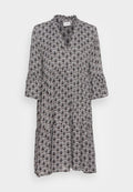 Schwarz-weiß gemustertes Kleid mit rüschendem Ausschnitt, ausgestellten Ärmeln und einem gestuften Rock mit Fächer-Motiv.