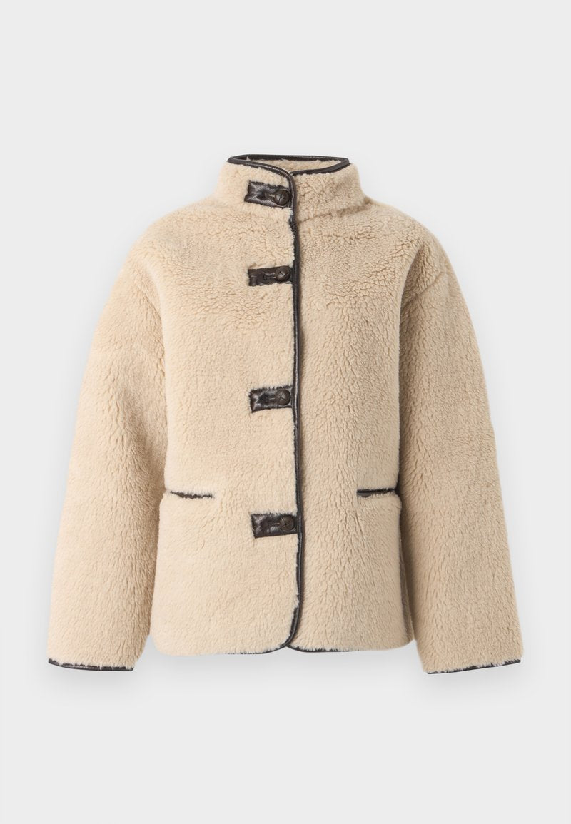 Cremefarbige Jacke aus Kunstpelz mit hohem Kragen, Knopfverschluss und dunkler Einfassung. Verfügt über zwei Fronttaschen und eine kastige Silhouette.