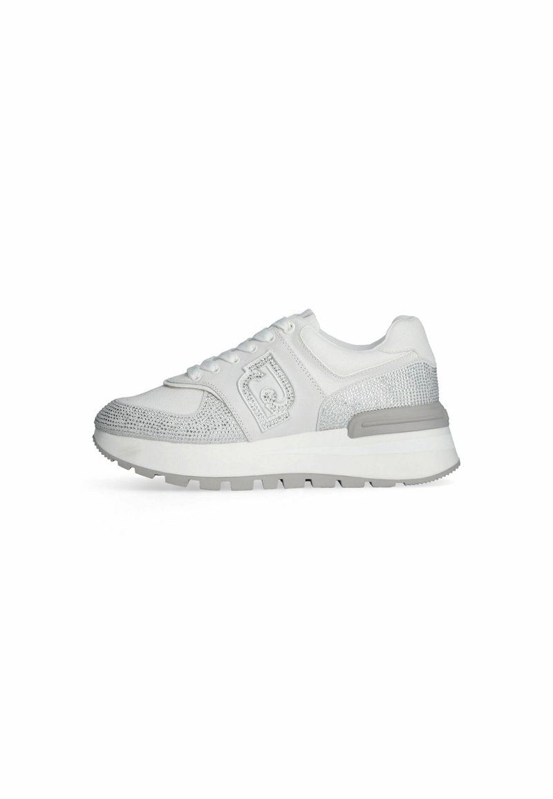 Weiße Sportschuh mit strukturiertem Mesh-Obermaterial, silbernen Akzenten, Schnürverschluss und einer robusten grauen Sohle mit Traktionsmustern.