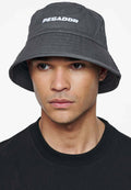 Grau Bucket Hat mit "PEGADOR"-Logo in Weiß, aus weichem Stoffmaterial und breitem, nach unten geneigtem Rand. Getragen von einem Modell mit einem schwarzen Shirt.