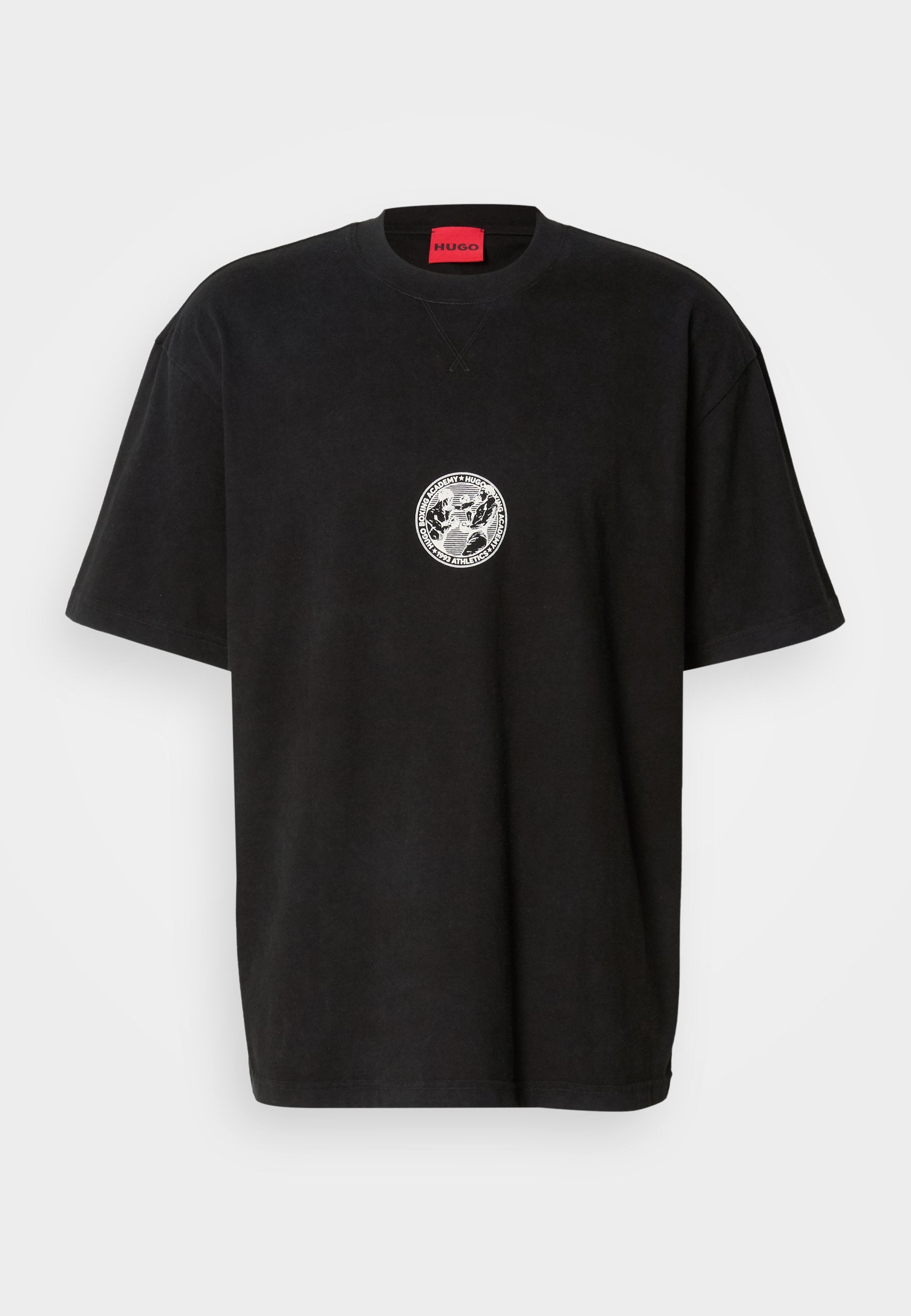 Schwarzes, oversized T-Shirt mit kurzen Ärmeln, einem kleinen weißen runden Grafikmotiv auf der Brust und einem roten Etikett im Kragen mit der Aufschrift "HUGO."