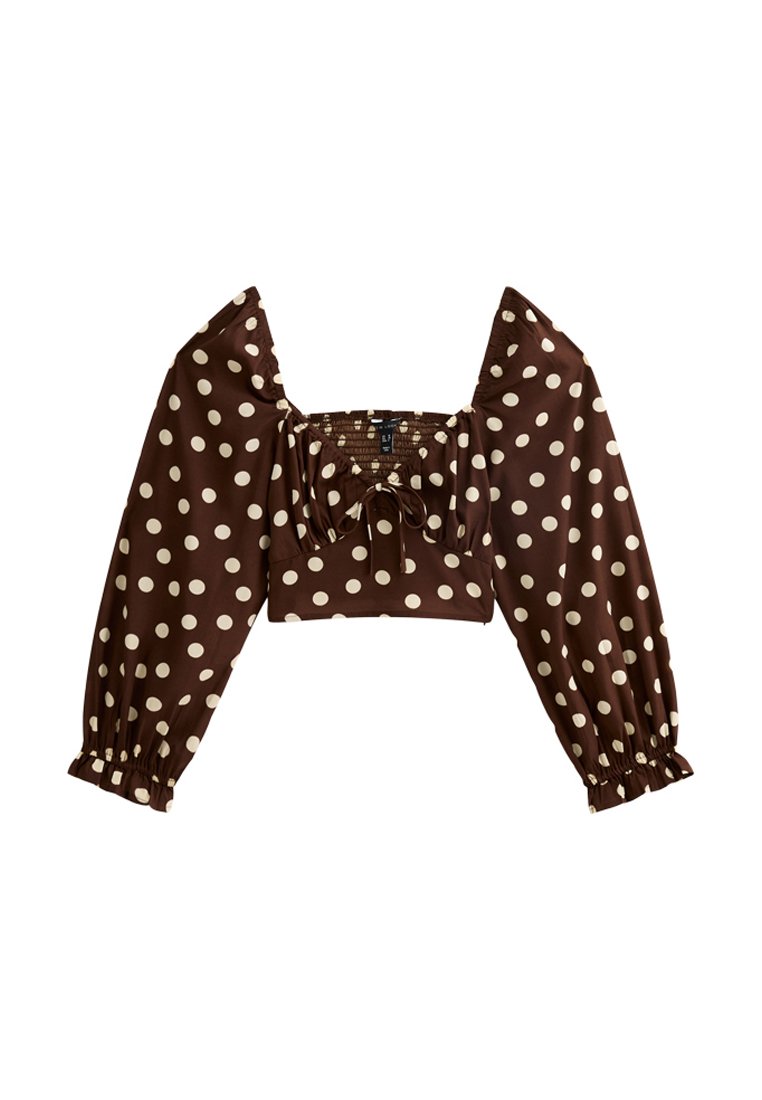 Braunes Polka-Dot-Crop-Top mit langen Puffärmeln, quadratischem Ausschnitt und gerafftem Oberteil. Der Stoff ist glatt mit einem dezenten Glanz.