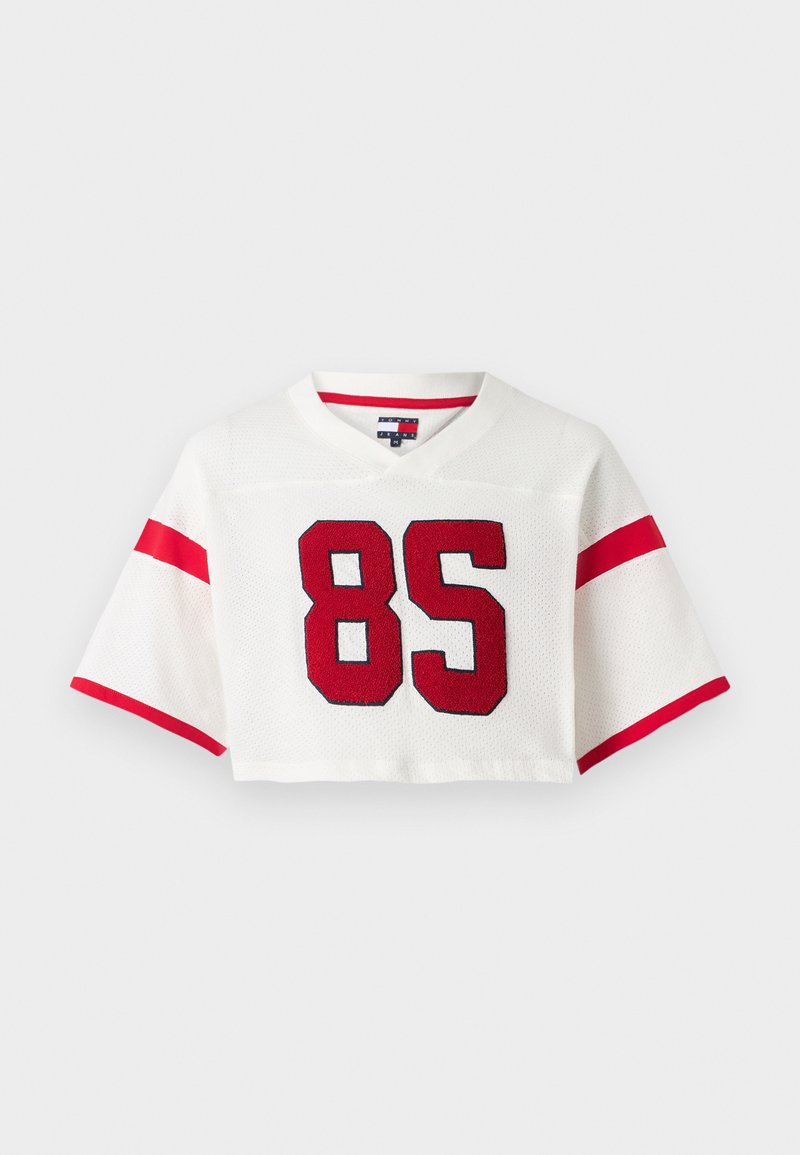 Beschnittenes weißes Fußballtrikot aus Netzstoff. Verfügt über rote Streifen an den Ärmeln und eine große rote Zahl '85' auf der Vorderseite.