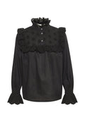 Schwarze Bluse mit langen Ärmeln. Verfügt über einen hohen, gerafften Kragen, dekorative florale Stickereien und gewellte Augenlochausschnitte an den Ärmeln.