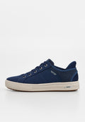 Marineblaue Low-Top-Sneaker mit weißer Gummisohle, Metallösen, Stoffoberfläche und gebrandetem Seitendetail vor weißem Hintergrund.