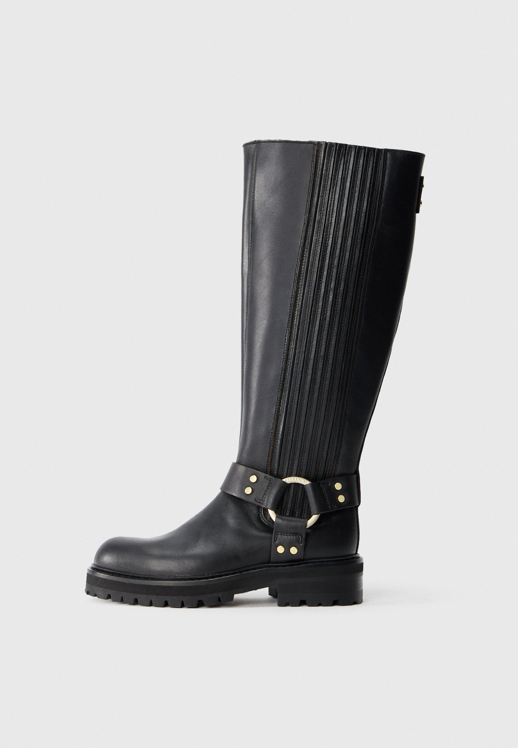 Schwarze kniehohe Lederstiefel mit elastischen Rippeneinsätzen, Profilsohle und dekorativem Riemen mit goldfarbener Metallring und Nieten.