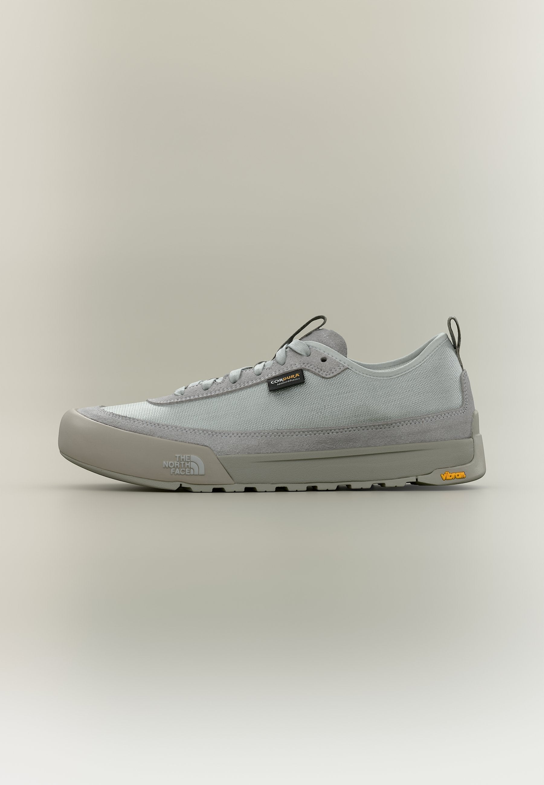 Hellgrauer Sneaker mit niedrigem Schaft, Mesh- und Wildleder-Obermaterial, Schnürverschluss, The North Face- und Vibram-Logos auf Sohle und Seite.