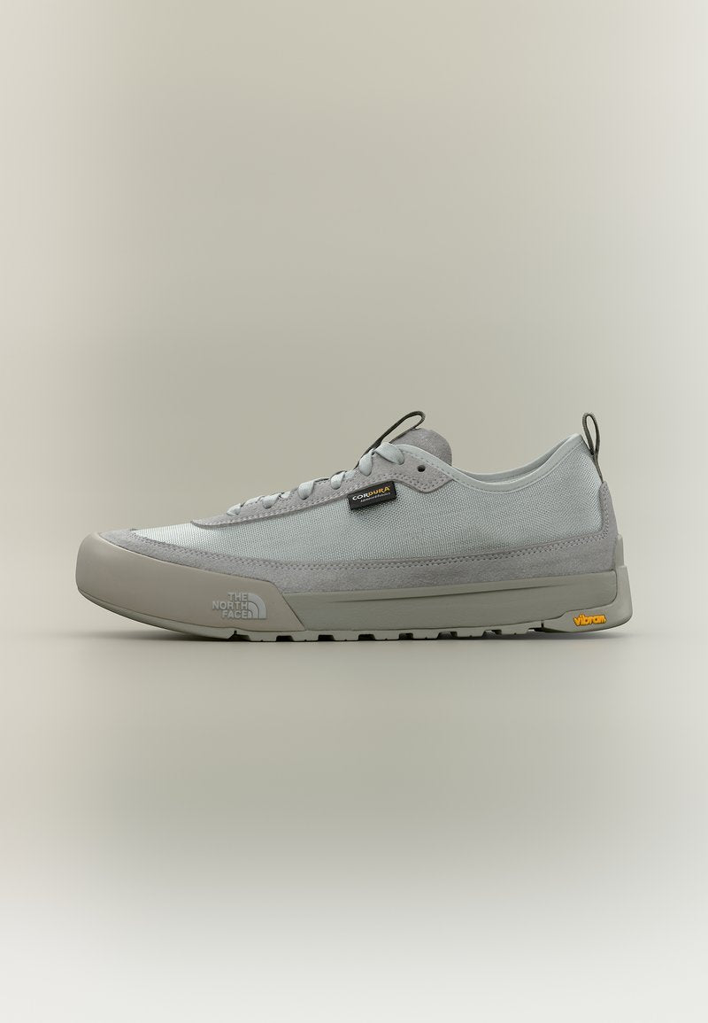 Hellgrauer Sneaker mit niedrigem Schaft, Mesh- und Wildleder-Obermaterial, Schnürverschluss, The North Face- und Vibram-Logos auf Sohle und Seite.