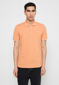 Polohemd aus leichtem orangefarbenem Baumwollstoff mit einer Knopfleiste mit drei Knöpfen, kontrastierenden weißen Kragenstreifen und einem kleinen Logo auf der Brust.