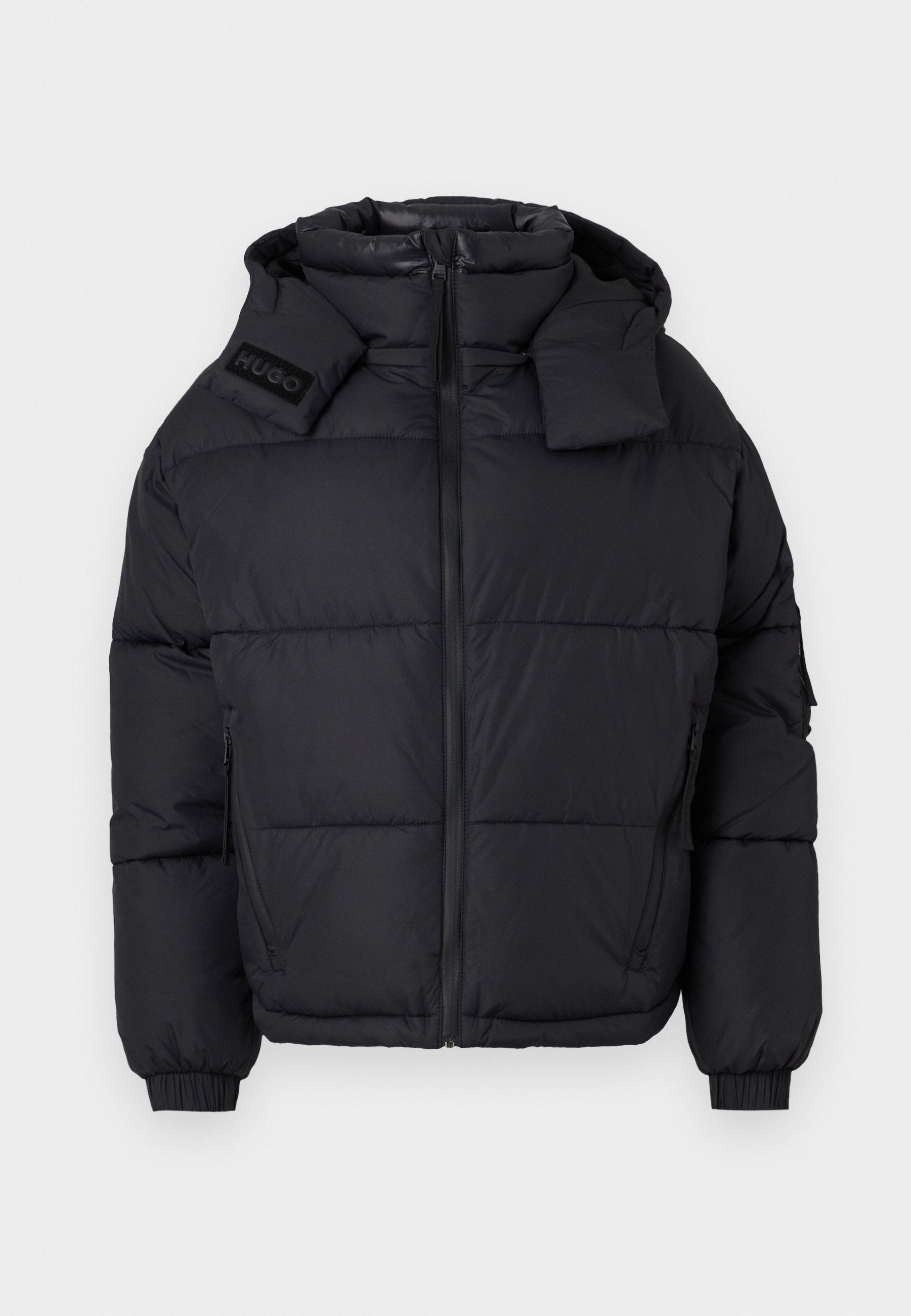 Schwarze Pufferjacke mit hohem Kragen und abnehmbarer Kapuze, ausgestattet mit einem Reißverschluss auf der Vorderseite, elastischen Bündchen und einem eingeprägten Logo auf der Schulter.