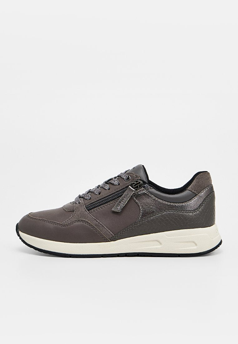 Grauer Sneaker mit Schnürung vorne, seitlichem Reißverschluss, texturierter Ferse und weißer Sohle auf einfachem, hellem Hintergrund.