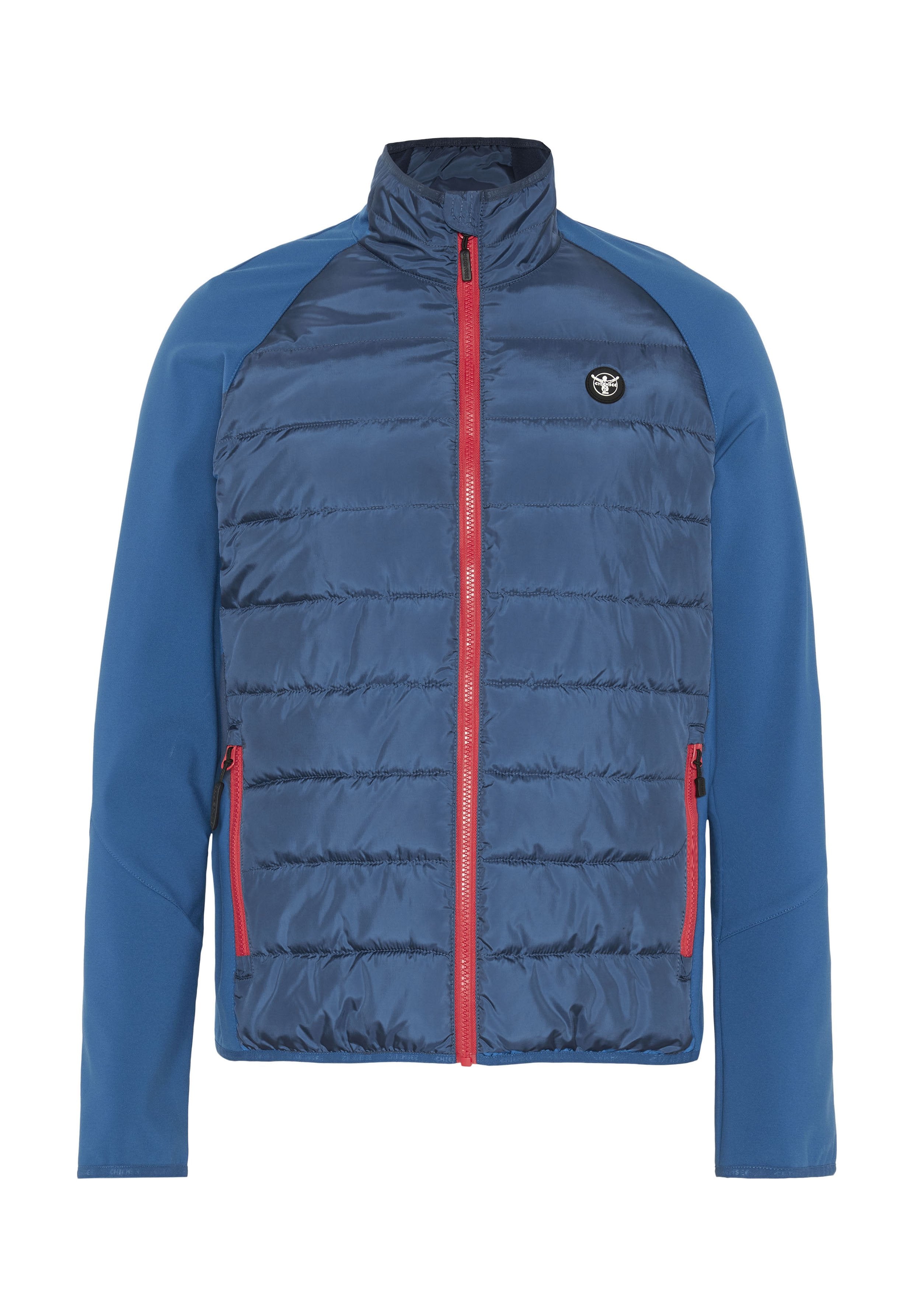Blaue Jacke mit gesteppter Vorderseite, ausgestattet mit einem hohen Kragen und rotem Reißverschluss. Glatte Stoffärmel und Brustbereich. Logo auf der linken Seite.