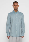 Helles blaues, langärmliges Button-up-Hemd aus Chambray-Stoff. Verfügt über einen Button-Down-Kragen und eine einzelne Brusttasche. Glatte Textur.