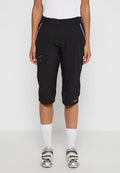 Schwarze Radsportshorts aus leichtem Material, ausgestattet mit Reißverschlusstaschen, einer taillierten Passform und weißen Akzenten. Knie-lange Ausführung.