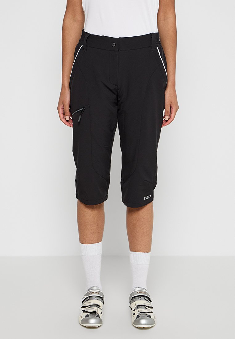 Schwarze Radsportshorts aus leichtem Material, ausgestattet mit Reißverschlusstaschen, einer taillierten Passform und weißen Akzenten. Knie-lange Ausführung.