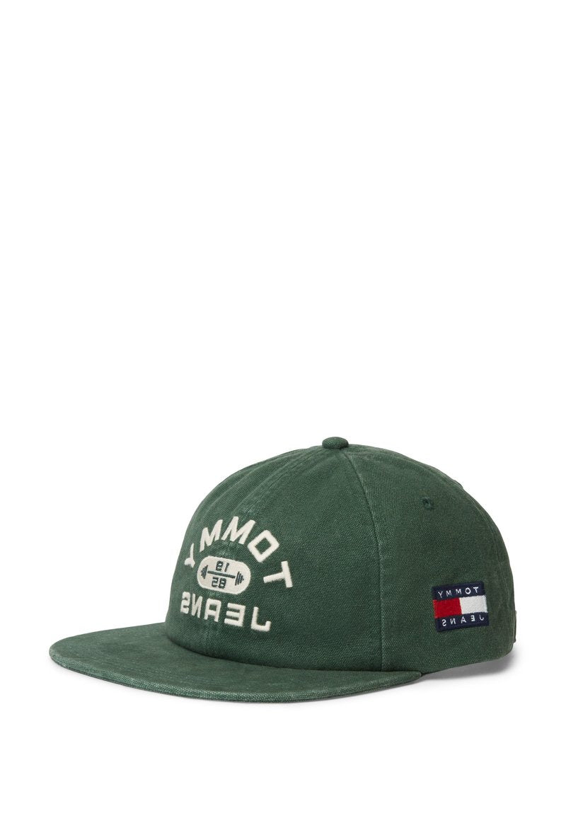 Grüne Baumwollmütze mit gebogenem Schirm, weißer Aufschrift "TOMMY JEANS" und Logo sowie einem Abzeichen in den Farben Rot, Weiß und Blau an der Seite.