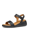 Schwarze Keilsandalen mit zwei verstellbaren Riemen, einer strukturierten Überlagerung auf dem vorderen Riemen und einem gepolsterten hellbraunen Fußbett.
