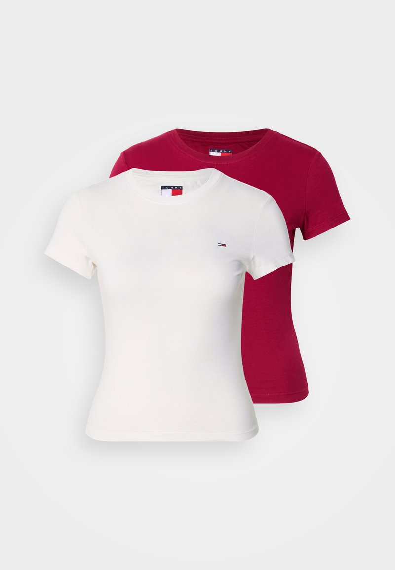 Zwei kurzärmelige Rundhalsshirts, eines weiß und eines dunkelrot, mit kleinen Logoaufnähern auf der Brust, vor weißem Hintergrund dargestellt.