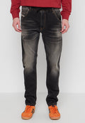 Schwarze Jeans aus Denim mit leichter Ausbleichung, Fünf-Taschen-Design, Kordelzugbund und schmaler Schnitt. Kombiniert mit orangefarbenen Sneakers.