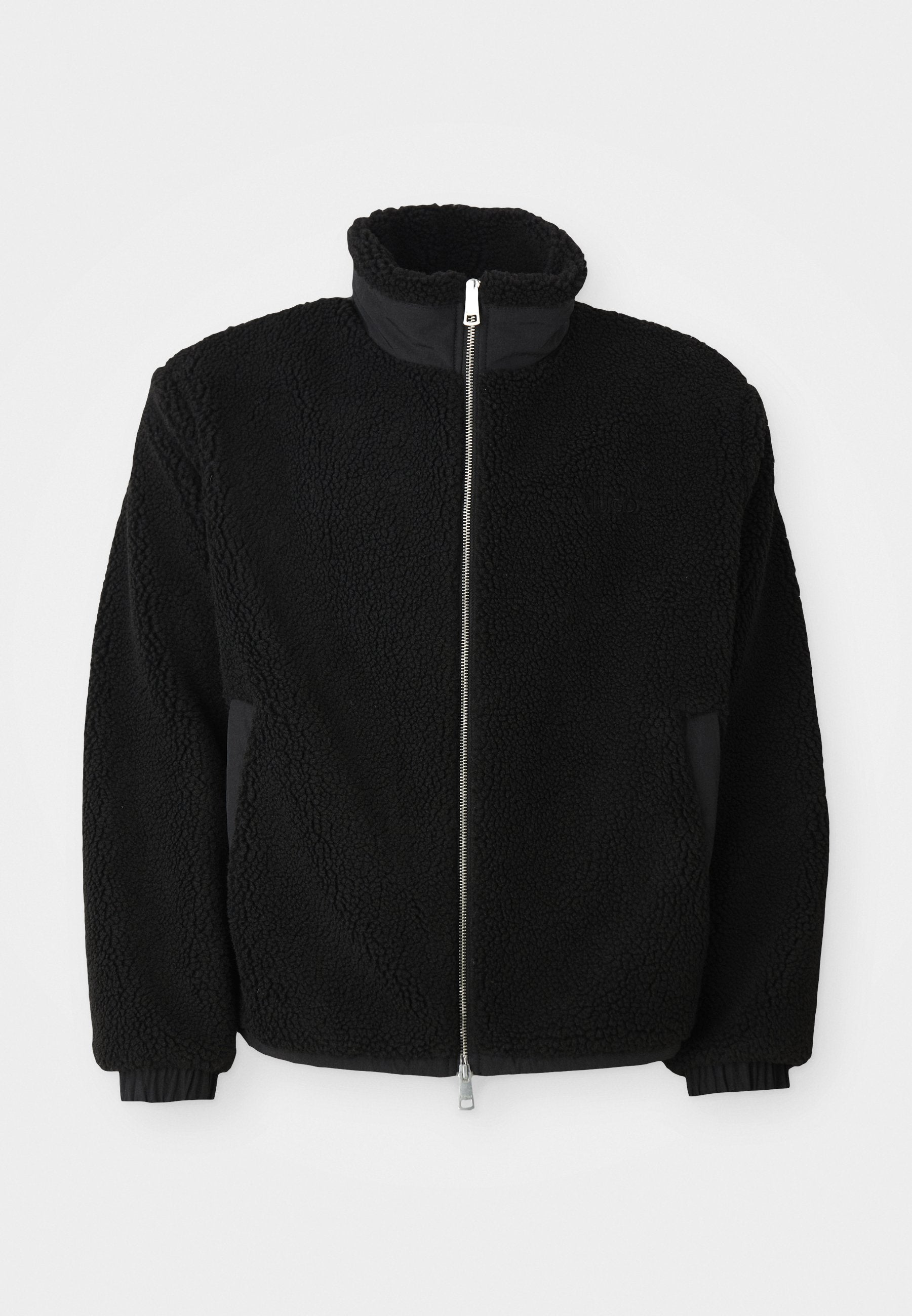 Schwarze Fleece-Jacke mit hohem Kragen, durchgehendem Reißverschluss und gerippten Bündchen. Der Stoff hat ein strukturiertes, fusseliges Aussehen.