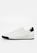 Weißer Ledersneaker mit schwarzem Fersenlasche und Sohle, mit weißen Schnürsenkeln und goldenem "AIGNER" Logo an der Seite.