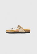 Beige Flip-Flop-Sandale aus einem veloursähnlichen Material, mit einem Korkfußbett, einer schwarzen Gummisohle und einem metallischen Schnallenakzent.
