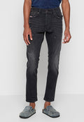 Dunkelgraue Slim-Fit-Jeans mit leichter Ausbleichung und distressed Akzenten, kombiniert mit strukturierten blauen Slippern.