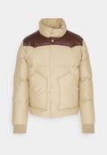 Beige Steppjacke mit braunen Leder-Schulterakzenten, Druckknöpfen, zwei Fronttaschen, gerippten Bündchen und hohem Kragen.