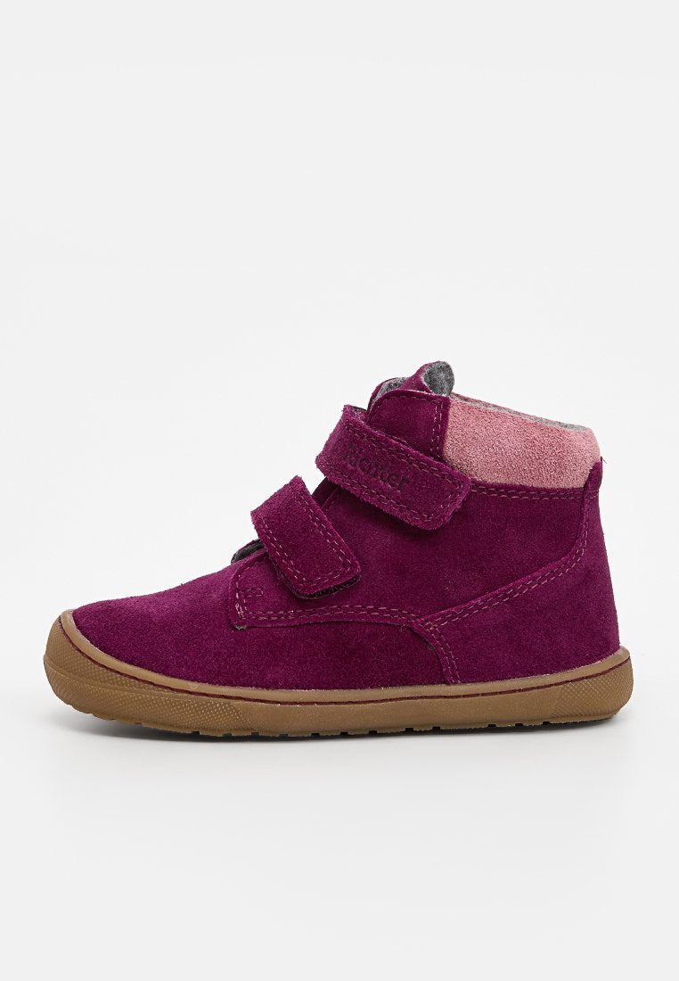 Lila Wildleder-Ankle-Boots mit einem weichen pinken Innenfutter, ausgestattet mit zwei Klettverschlüssen und einer braunen Gummisohle für guten Halt.