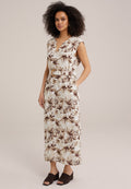 Maxikleid aus leichtem Stoff mit einem floralem Muster in Braun und Creme, V-Ausschnitt, kurzärmeligen Puffärmeln und einem passenden Gürtel. Braune Keil-Mules runden den Look ab.