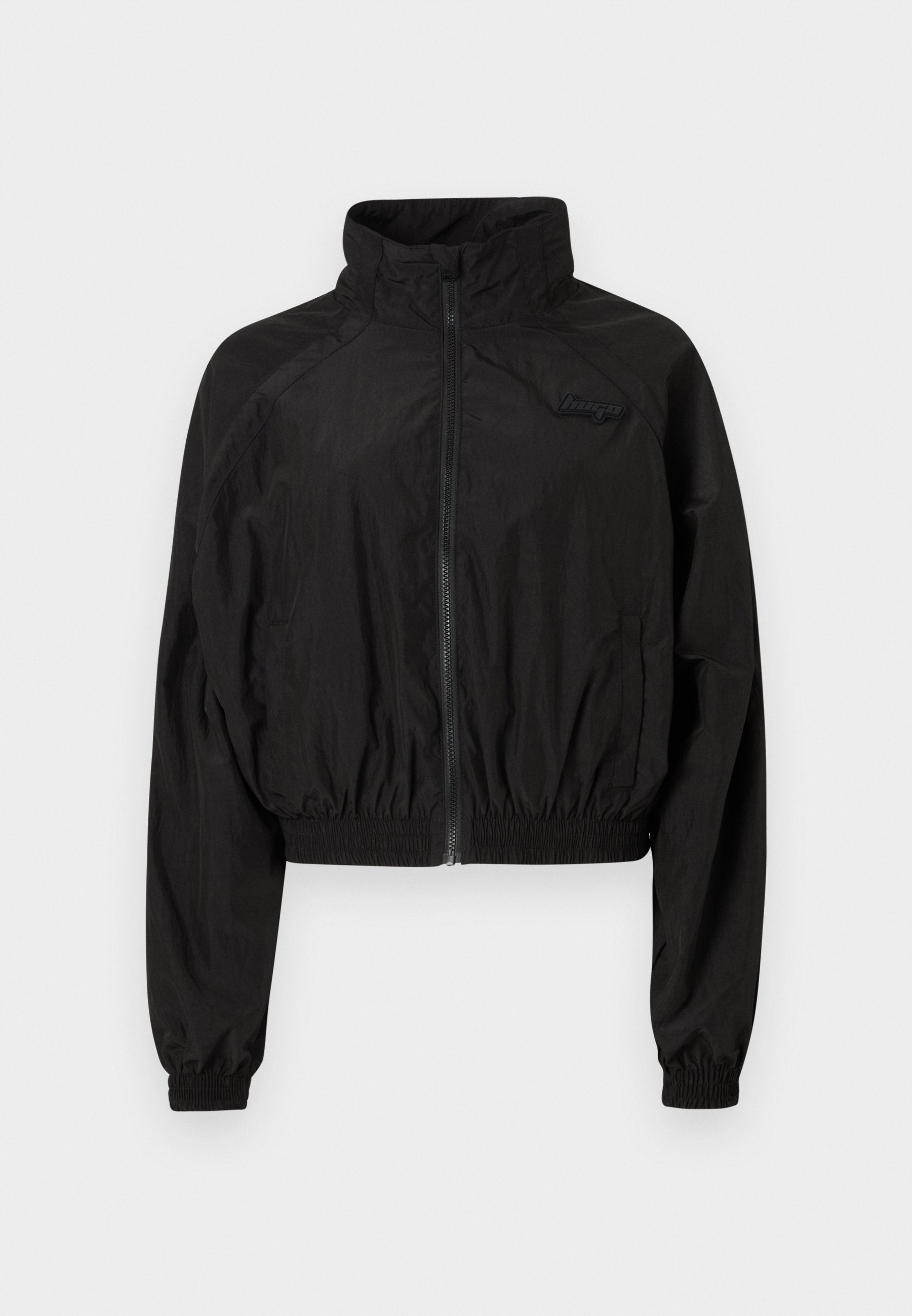 Schwarze, kürzere Jacke aus leichtem Stoff. Verfügt über einen hohen Kragen, elastische Bündchen und einen Reißverschluss vorne. Dezentes Logo-Detail auf der Brust.